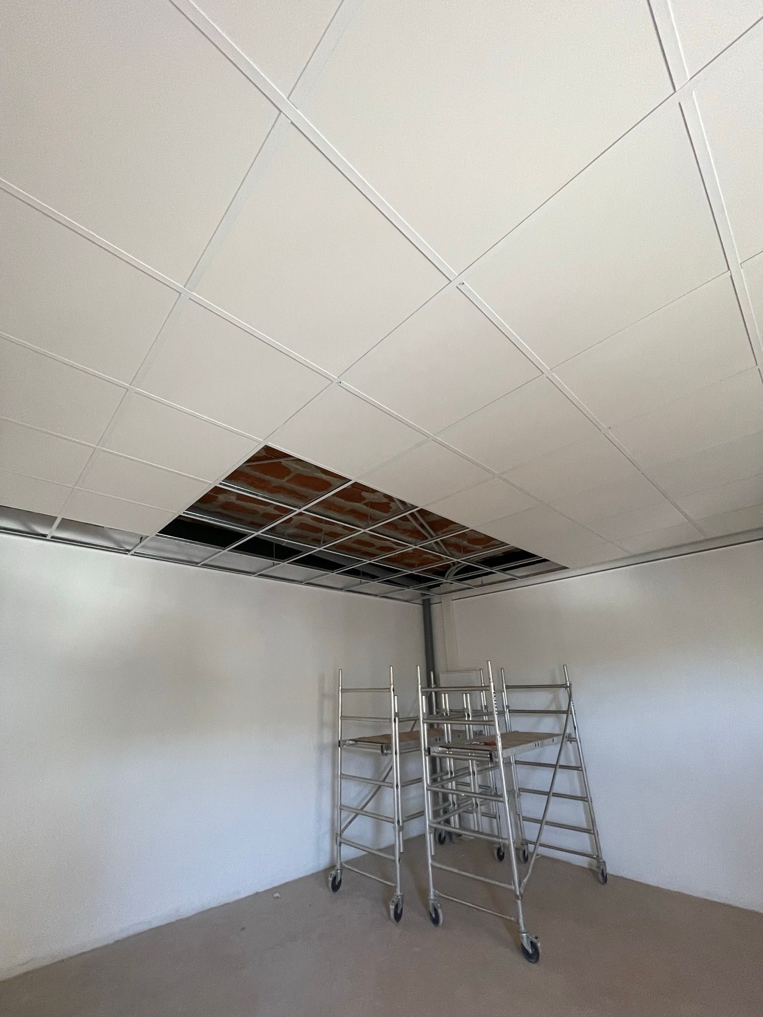 Una habitación con un andamio y un agujero en el techo.