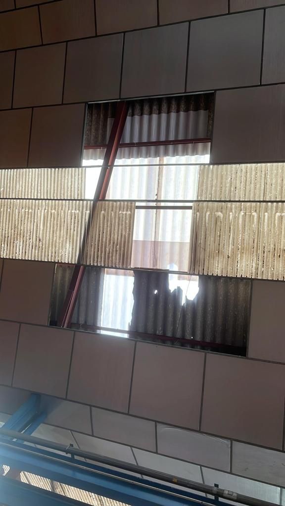 Una pared de ladrillos con un agujero que parece una ventana.