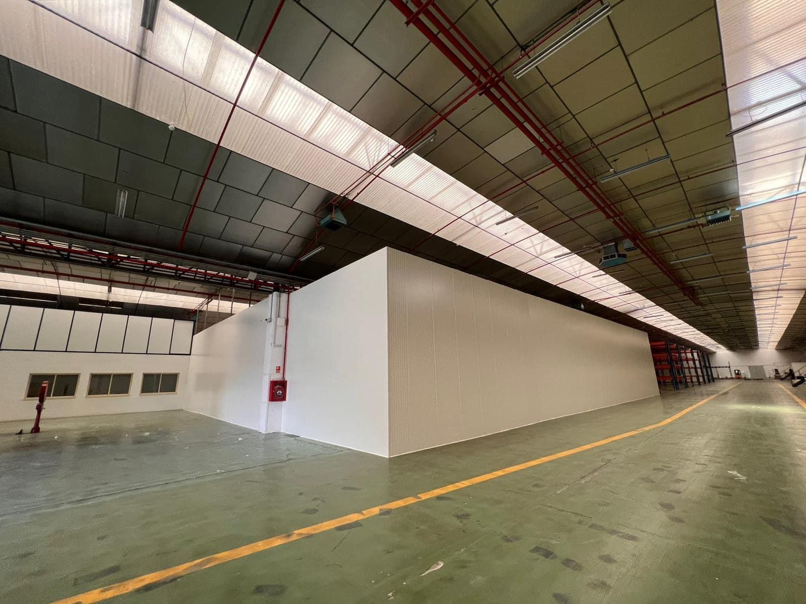 Un gran almacén con muchas ventanas y una línea amarilla en el suelo.