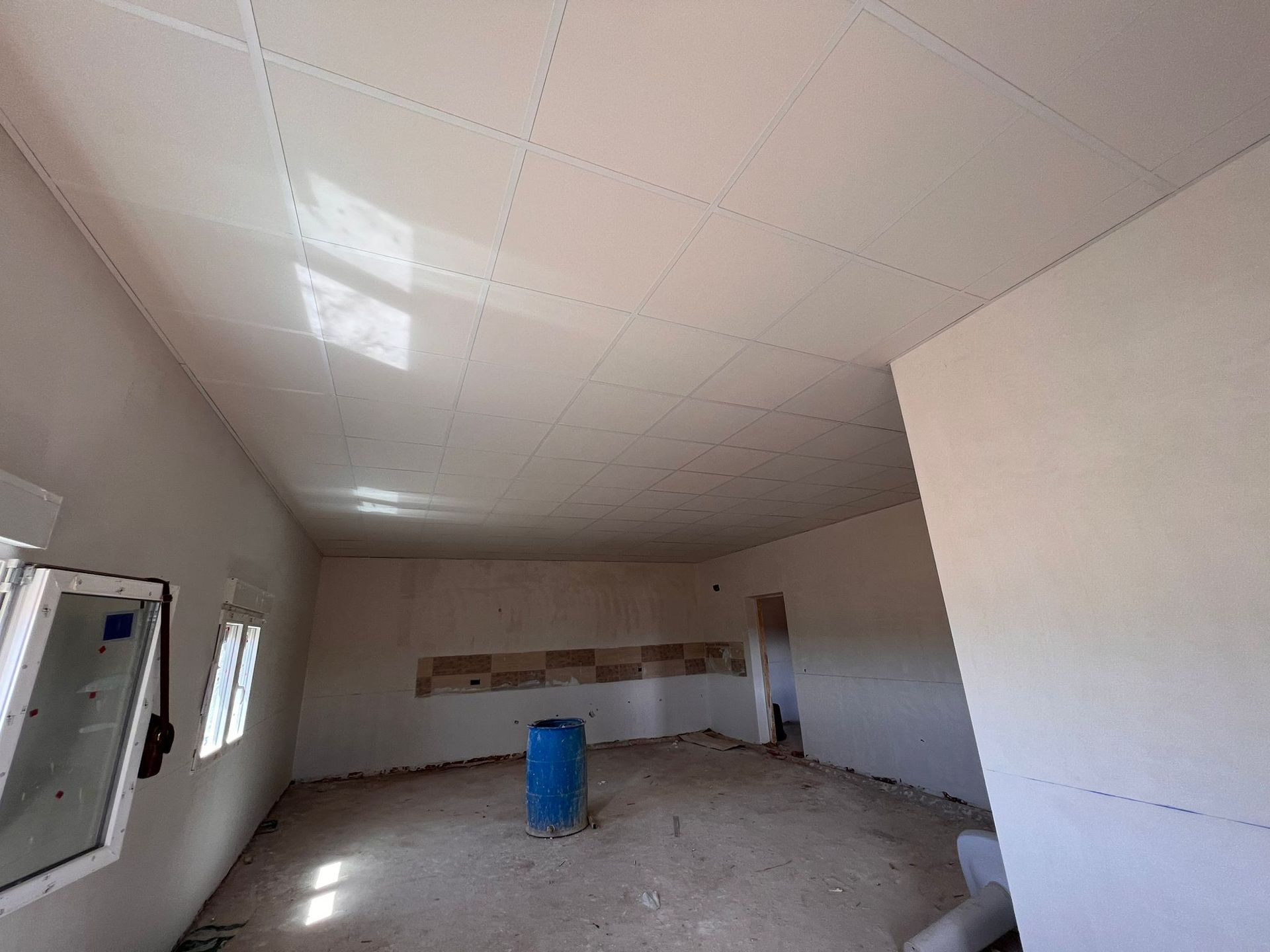 Hay un barril azul en el medio de la habitación.