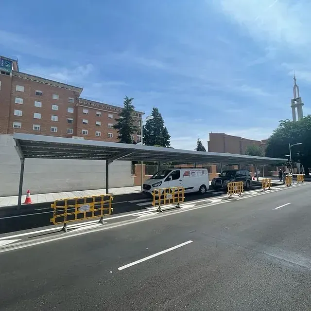 Una camioneta blanca está estacionada bajo un toldo al costado de la carretera.
