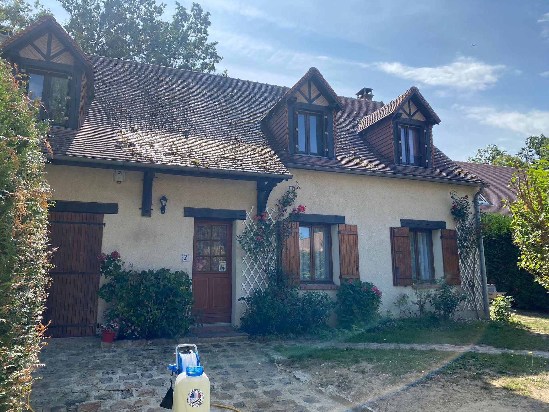 Un maison de face avant le nettoyage de la toiture