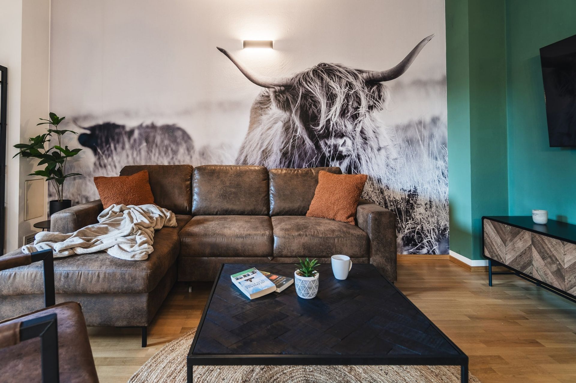 Modernes Wohnzimmer mit Kuhtapete im Apartment Kuhstadl in Bad Kleinkirchheim – ALPSTAY Apartments