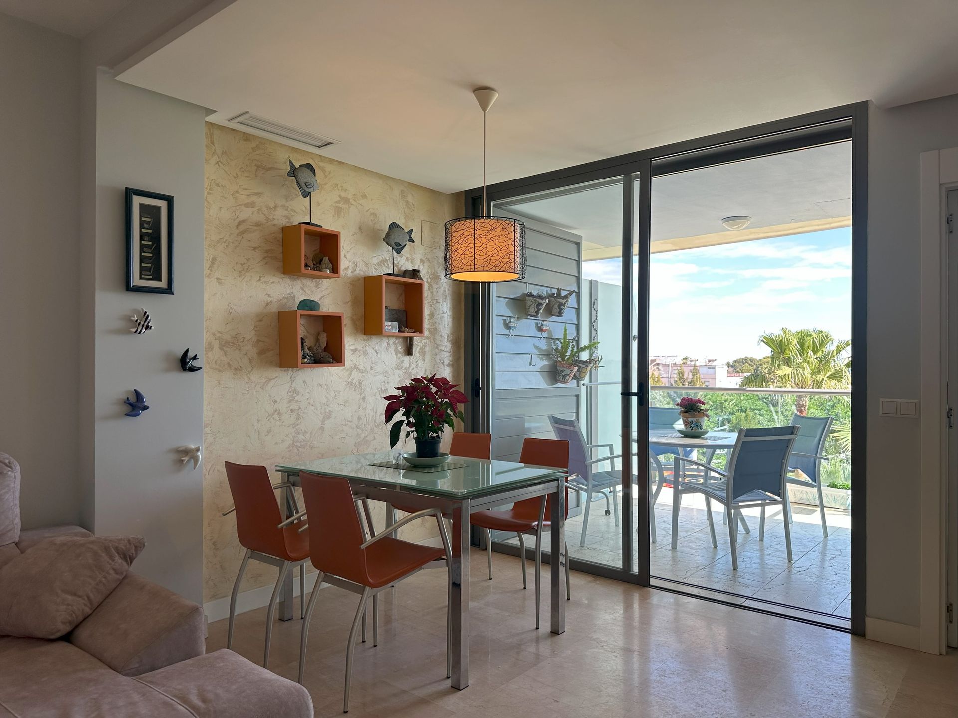 Una sala de estar con mesa y sillas y un balcón.