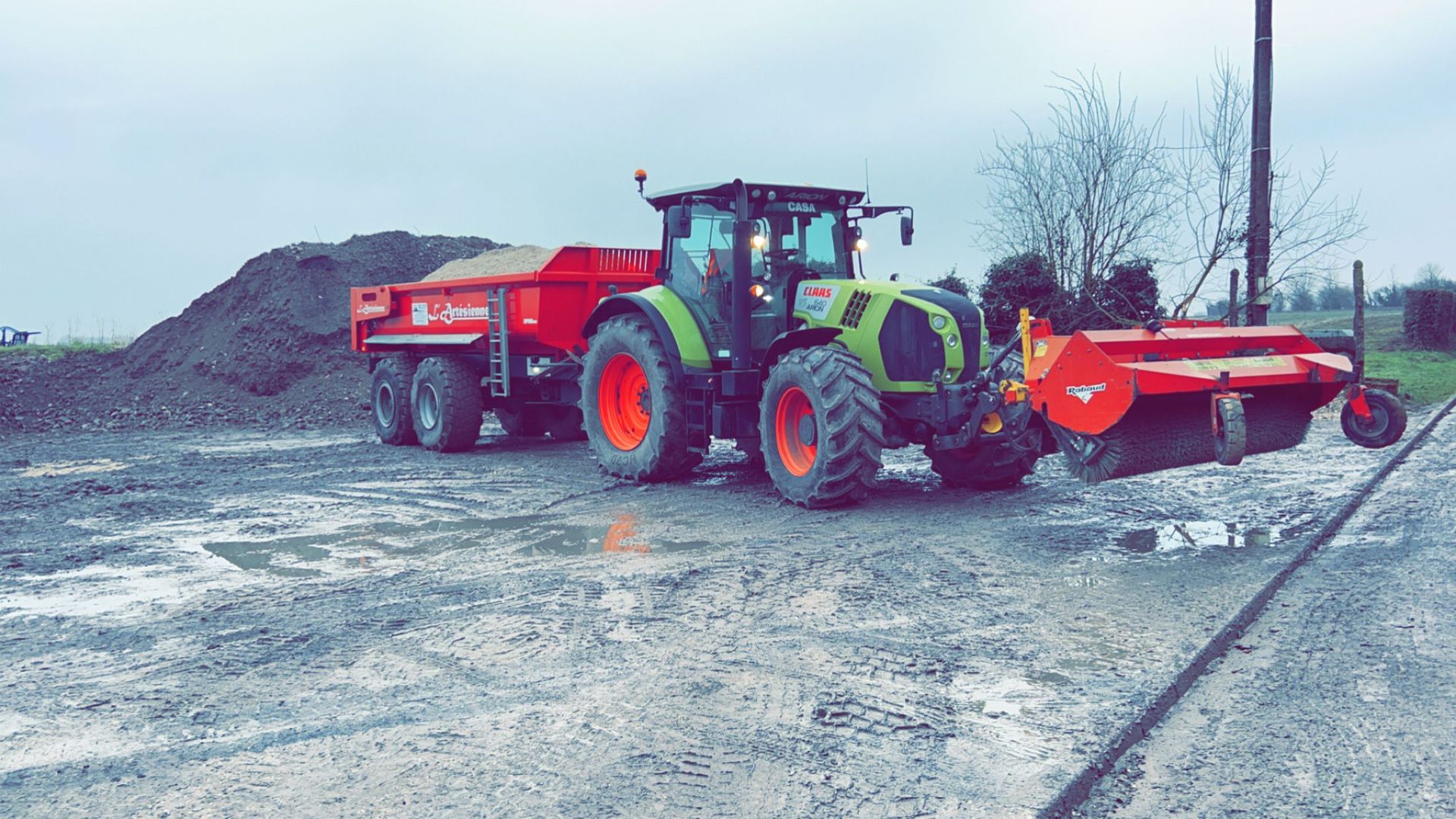 Un tractobenne rouge.