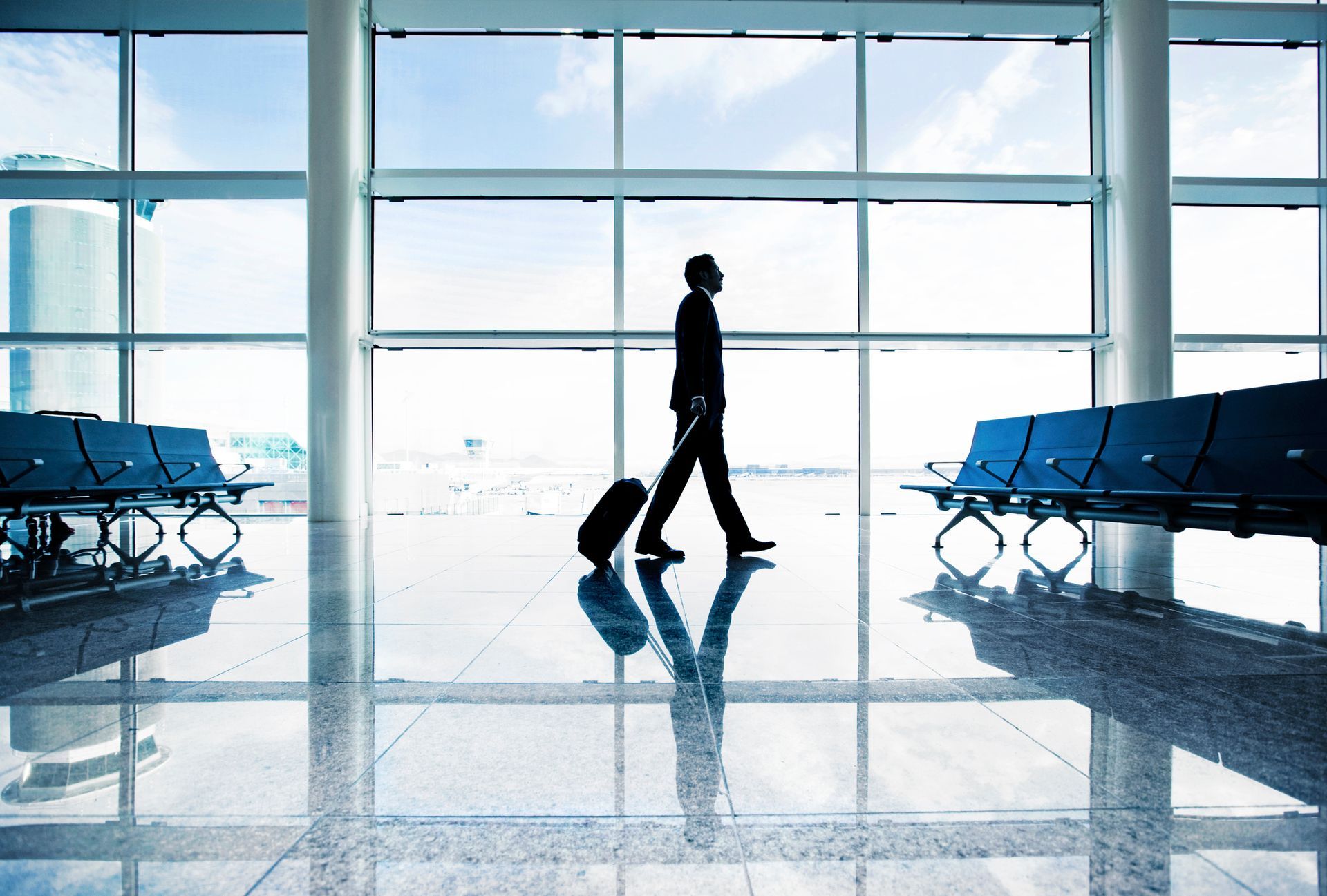 Un hombre camina por un aeropuerto con una maleta.