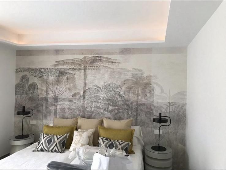 Un dormitorio con una cama, mesitas de noche y un cuadro en la pared.
