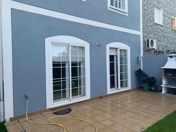 Una casa azul y blanca con una manguera delante de ella.