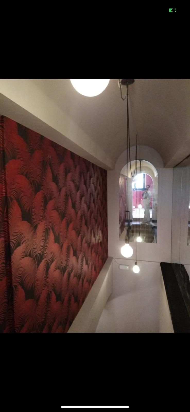 Un baño con una pared roja y una bañera.