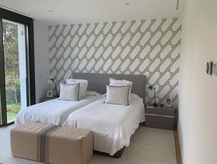 Un dormitorio con dos camas y una puerta corrediza de cristal.