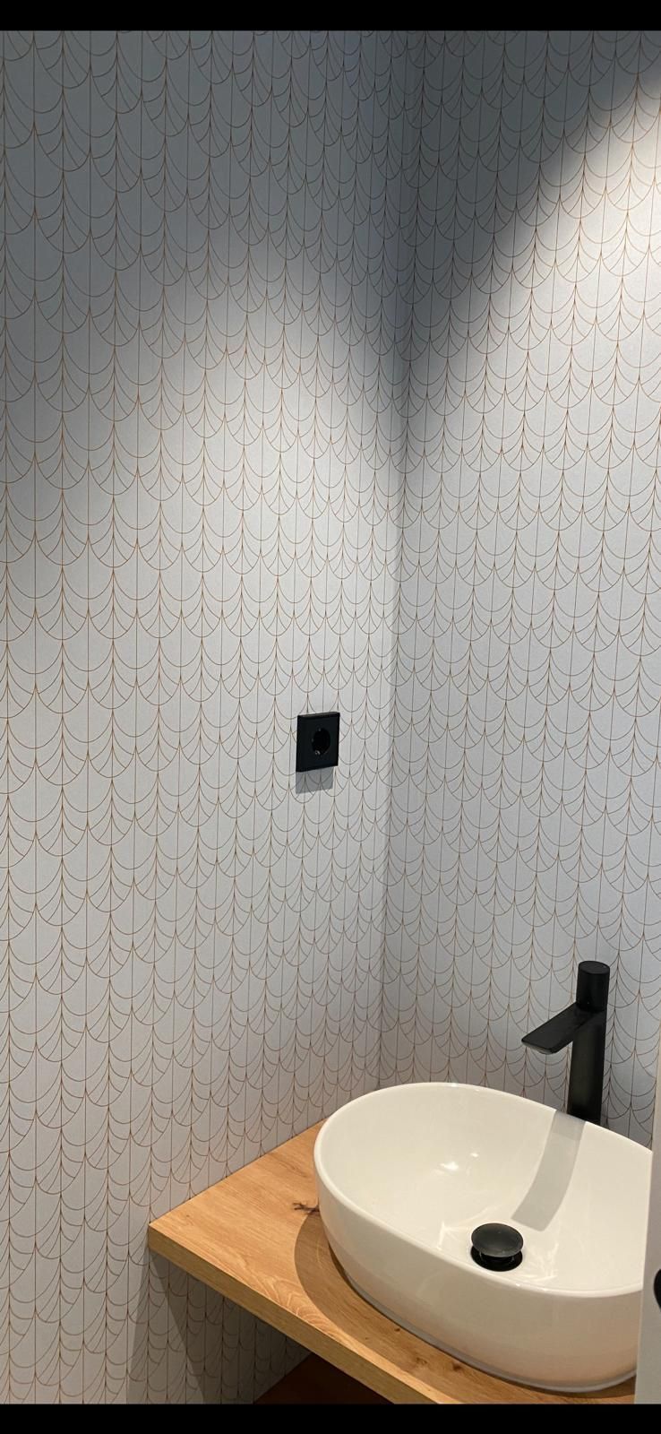 Un baño con lavabo y encimera de madera.