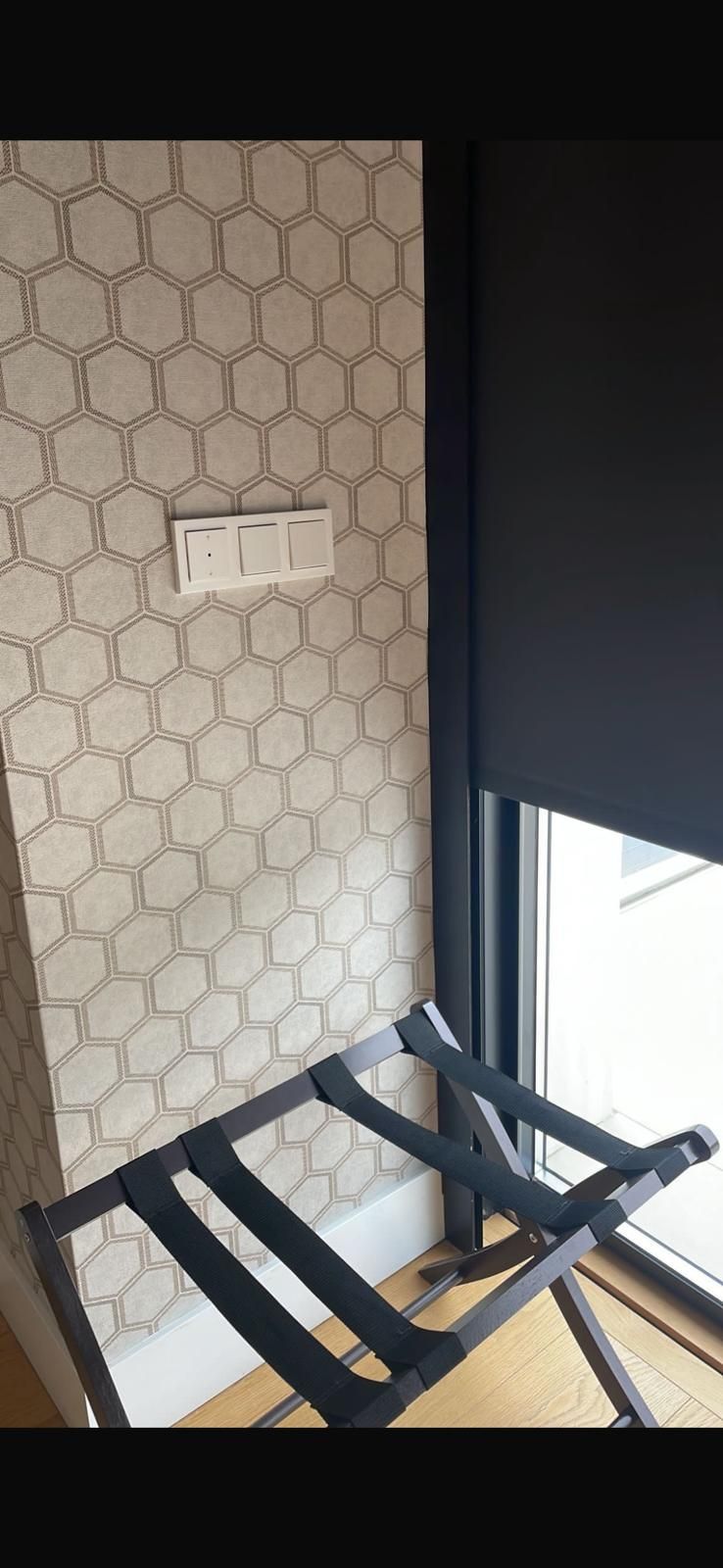 Un portaequipajes está colocado delante de una ventana en una habitación.