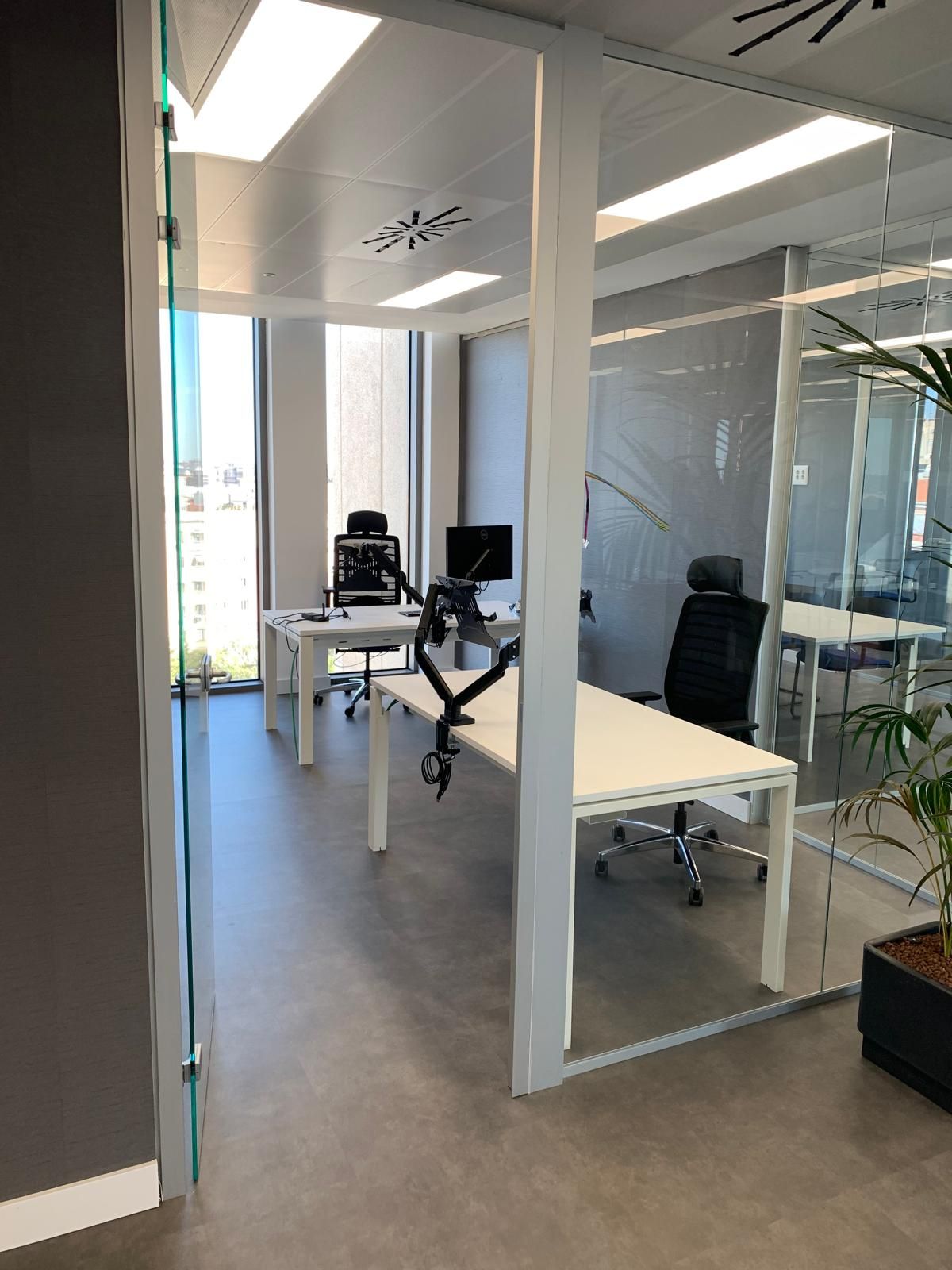 Una habitación con muchas ventanas, mesas y sillas.