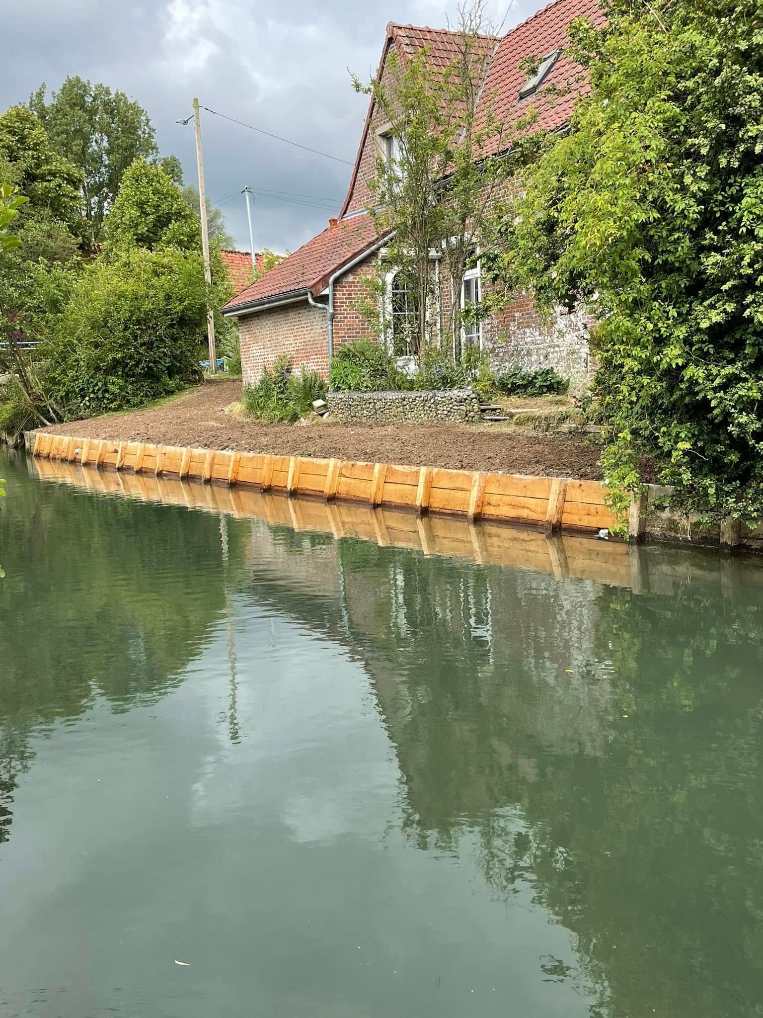 Berge avec planches en bois pour une maison près d'un canal