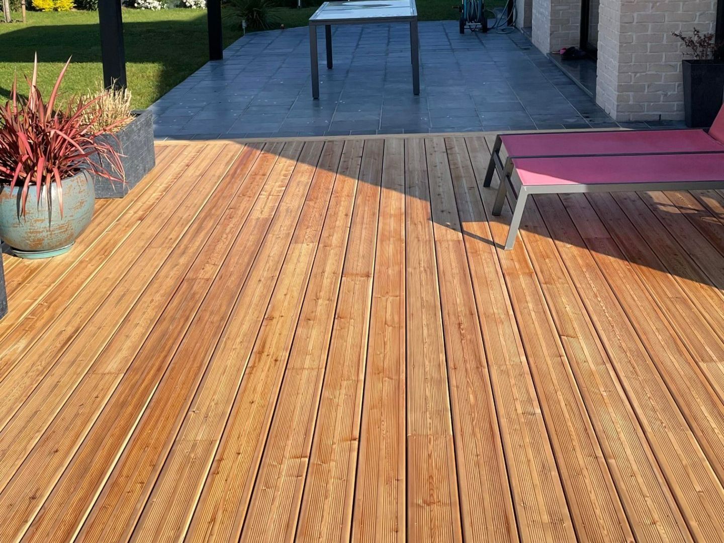 Terrasse en bois de teinte caramel, vue sur pergola