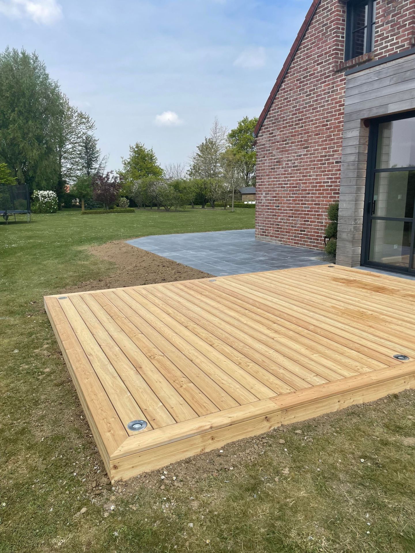 Petite terrasse en bois devant une baie coulissante