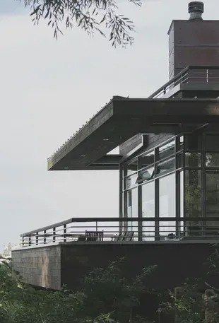 Una fotografía en blanco y negro de una casa moderna con balcón.