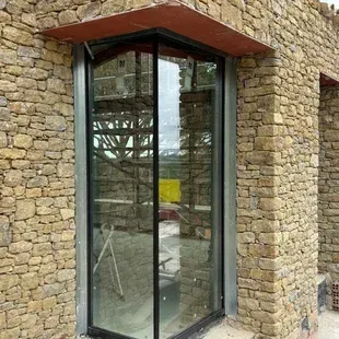 Un edificio de ladrillo con una gran ventana de vidrio en la esquina.