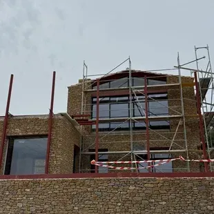 Se está construyendo un edificio de ladrillo con andamios alrededor.