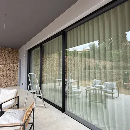 Un balcón con puertas corredizas de vidrio y una escalera.