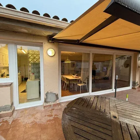 Un patio con una mesa y sillas bajo un toldo.