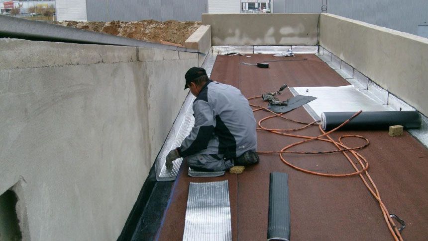 Artisan qui réalise l'étanchéité d'un toit-terrasse