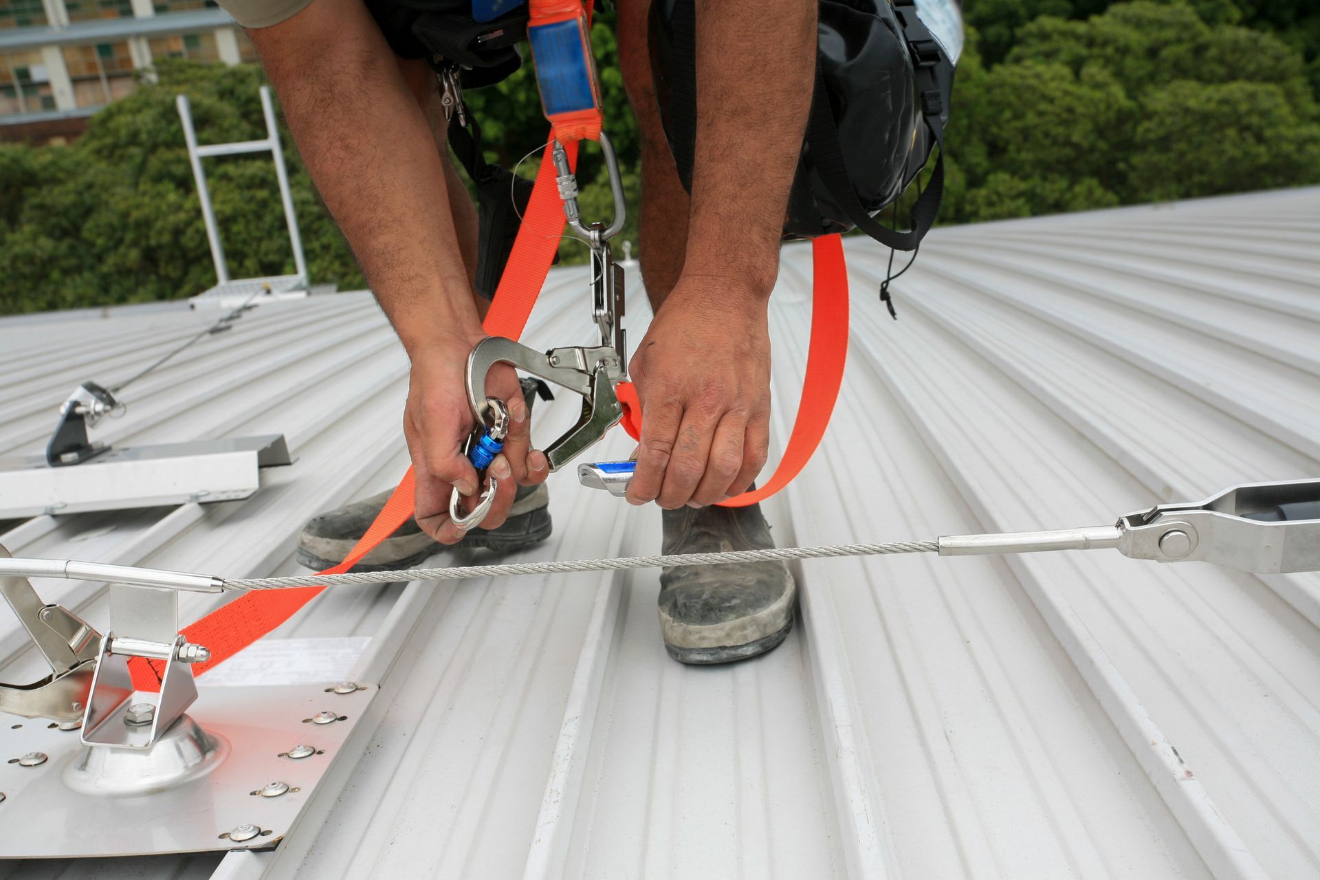 Cordiste sécurisé par son baudrier accroché à une ligne de vie avec des mousquetons