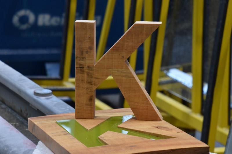 Ein Holzbuchstabe K, der auf einem Holzblock sitzt