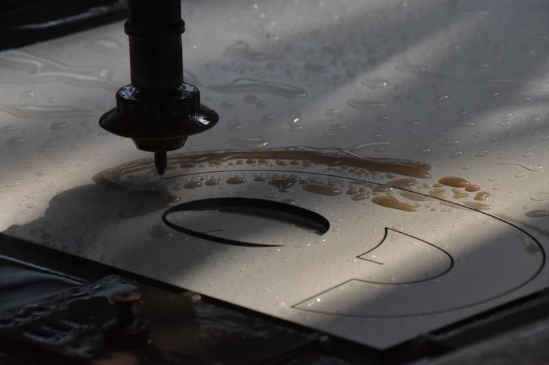 Eine Maschine schneidet ein Stück Papier mit Wasser.