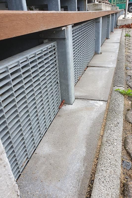 Eine Nahaufnahme eines Metallgitters auf einem Gehweg.