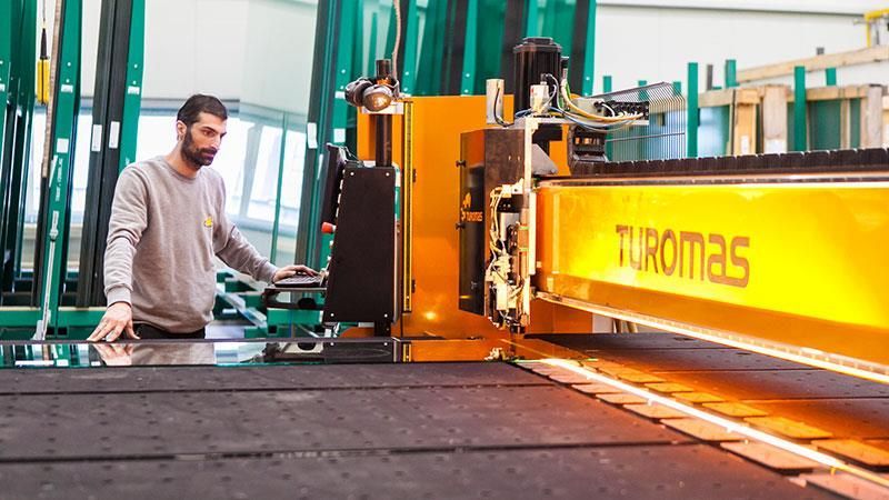 Ein Mann arbeitet in einer Fabrik an einer Maschine.