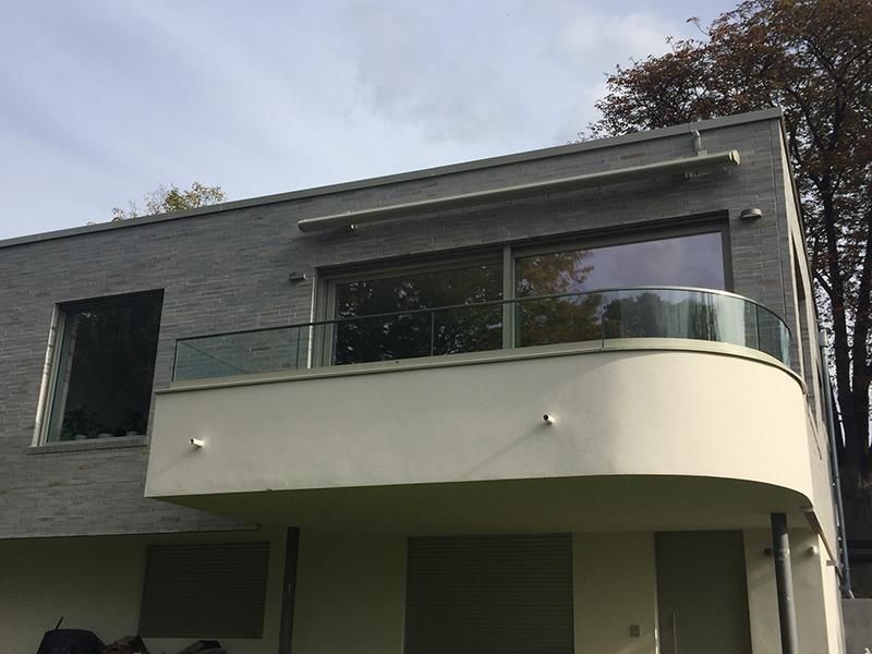 Ein großes Haus mit einem Balkon und einem großen Fenster