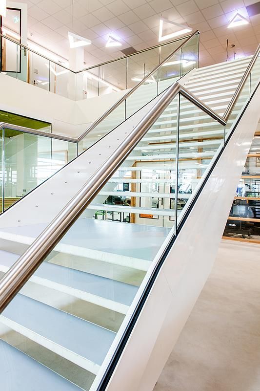 Eine weiße Treppe mit einem Glasgeländer in einem Gebäude