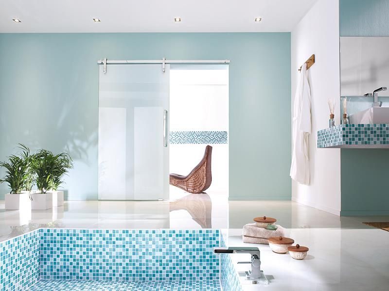 Ein Badezimmer mit blauen Fliesen und einer Glasschiebetür