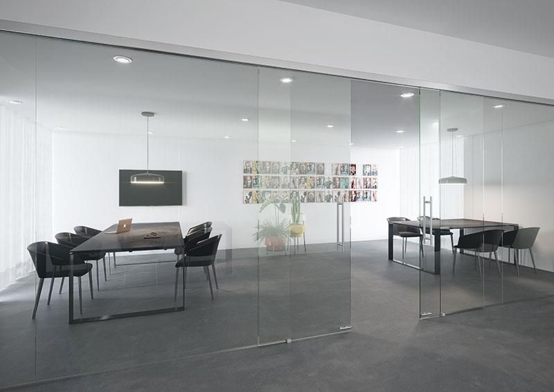 Ein Konferenzraum mit Glasschiebetüren und einem Tisch und Stühlen.