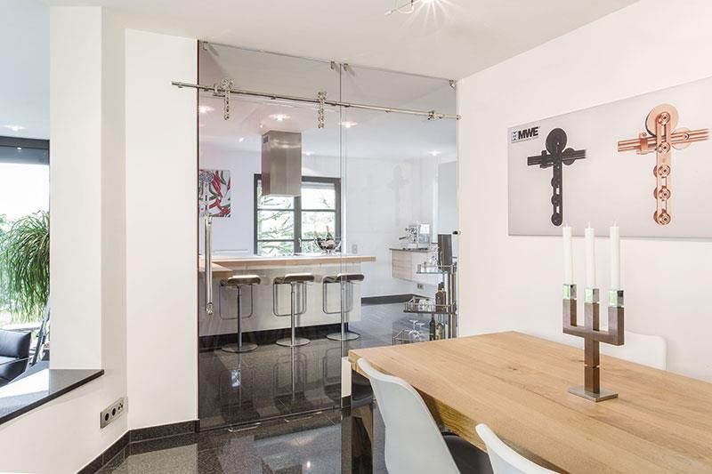 Ein Esszimmer mit einem Holztisch und Stühlen und einer Glastür