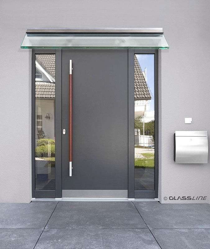 Eine graue Tür mit einem roten Griff und einem Glasdach