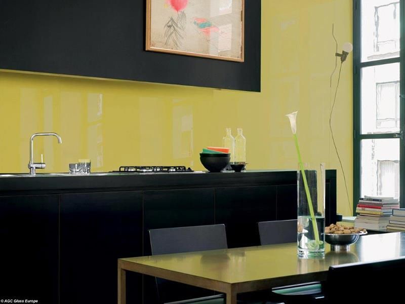 Eine Küche mit gelben Wänden und schwarzen Schränken