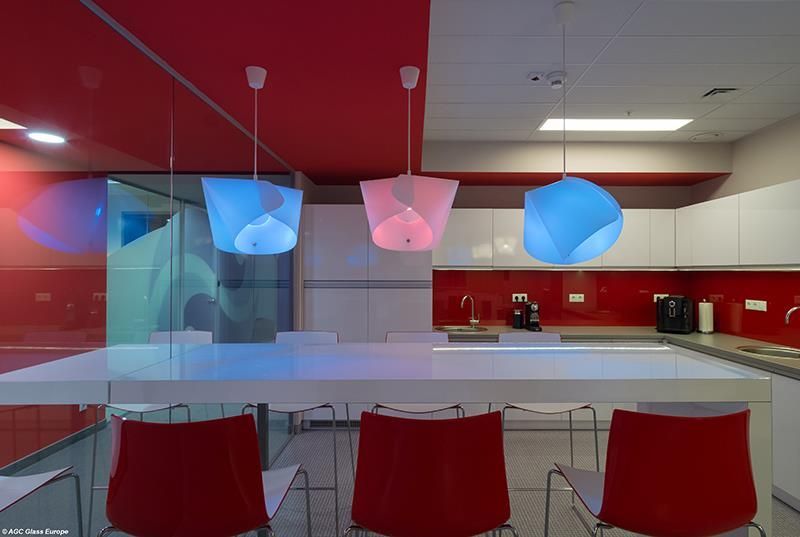 Eine Küche mit einem weißen Tisch und roten Stühlen