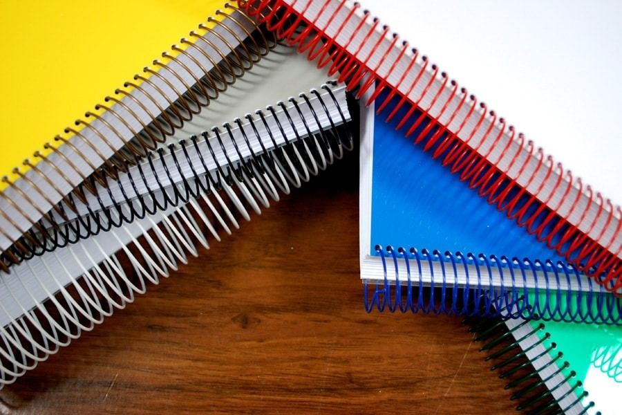 Un montón de cuadernos en espiral están apilados uno encima del otro