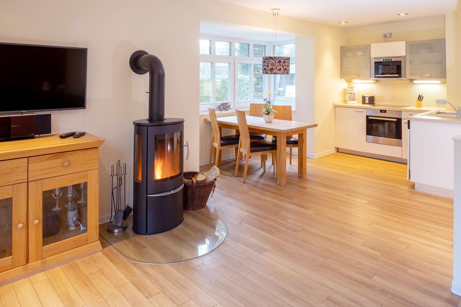 Wohnraum mit Holzböden, Küche, Essbereich und Kamin.