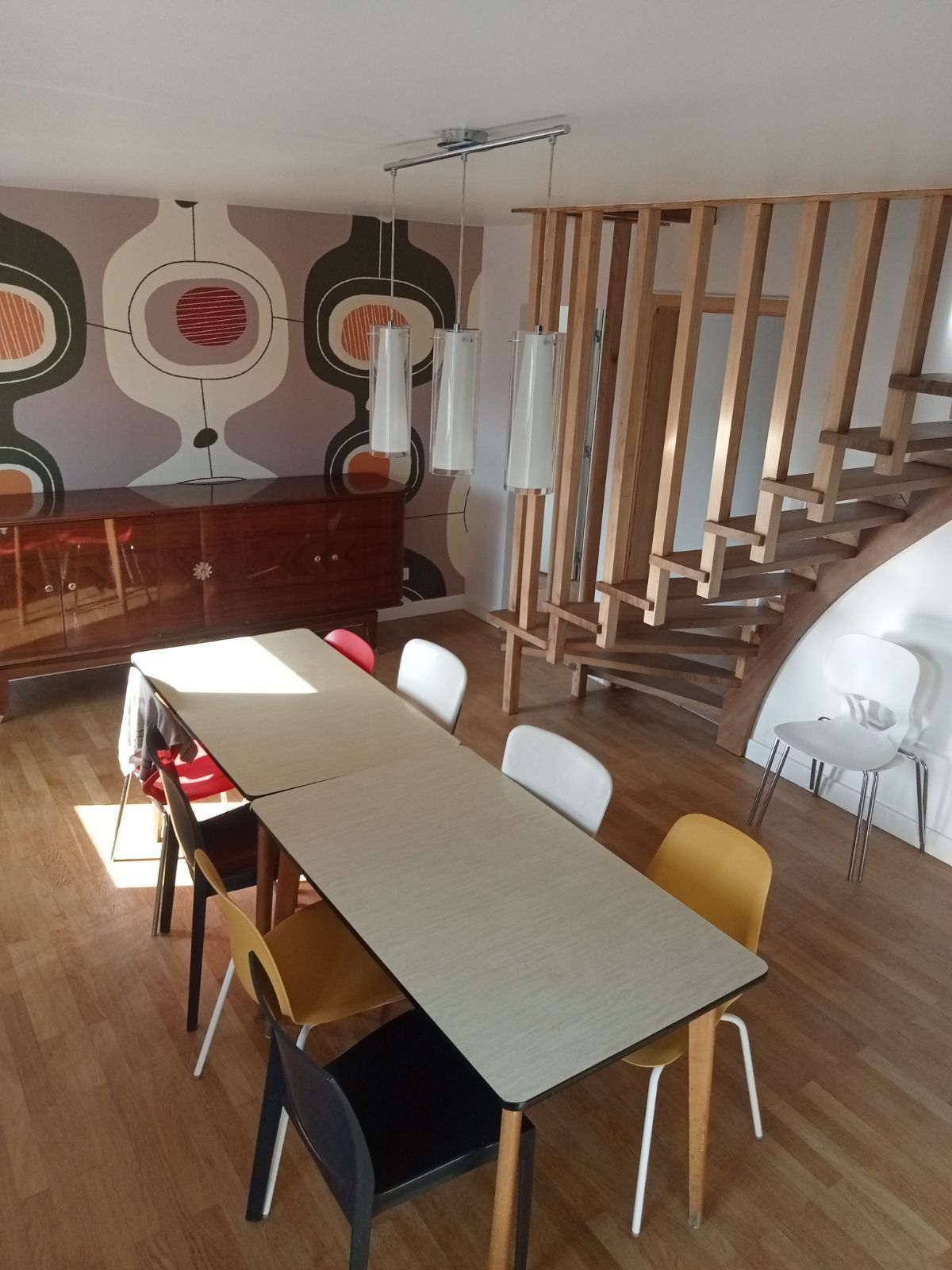 Un intérieur avec table, escalier et mur en papier peint