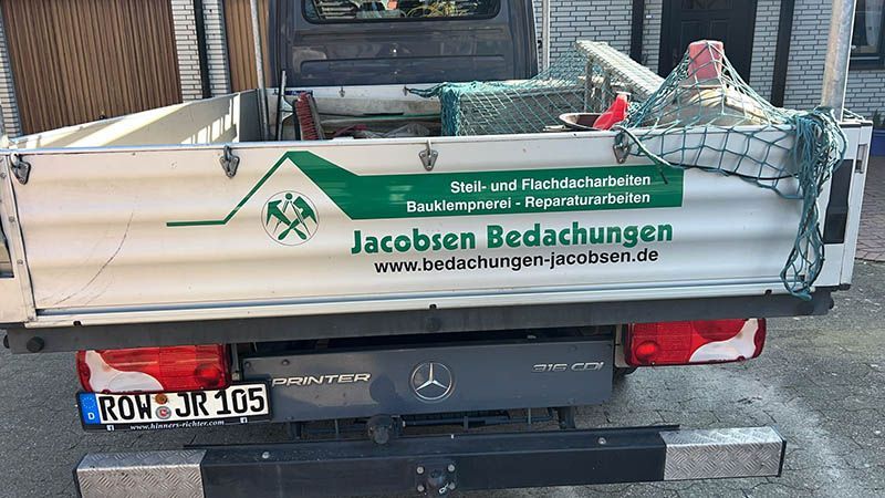 Ein Holzhaus ist von einer Vielzahl von Bauwerkzeugen umgeben.