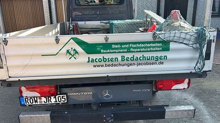 Ein Holzhaus ist von einer Vielzahl von Bauwerkzeugen umgeben.