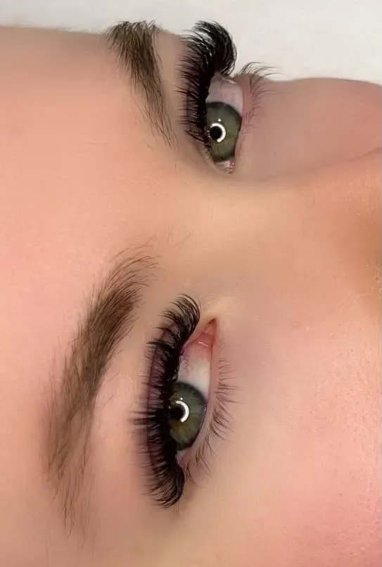 Primer plano de los ojos de una persona con pestañas largas y cejas bien definidas.