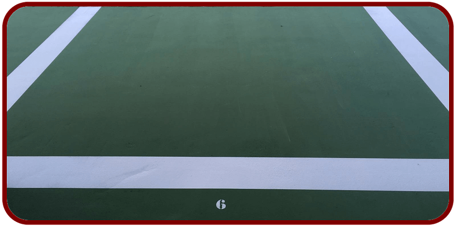 Des lignes blanches délimitent une section d'un terrain de sport sur une surface verte.