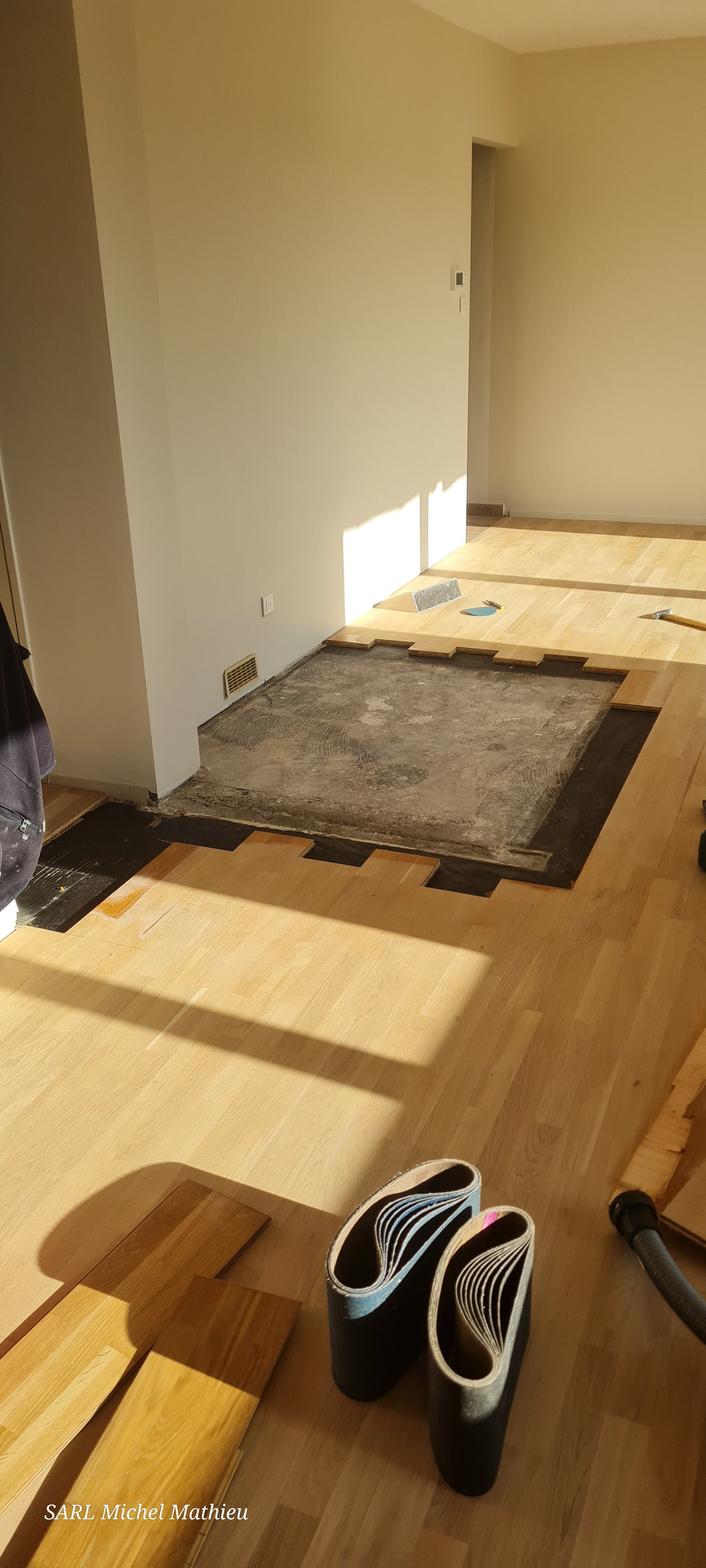 Pose de revêtement de sol avec une découpe qui laisse apparaître la surface sous-jacente