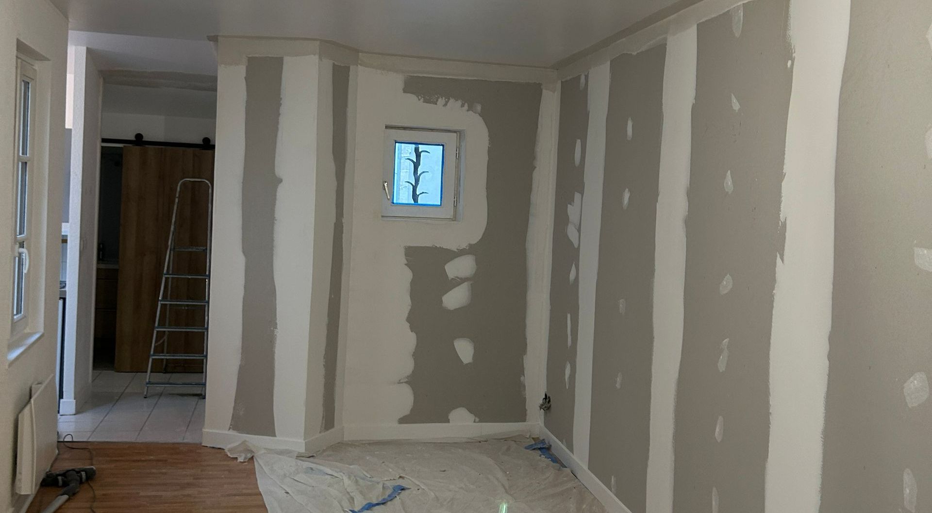 Pose de cloisons dans une pièce avec une petite fenêtre