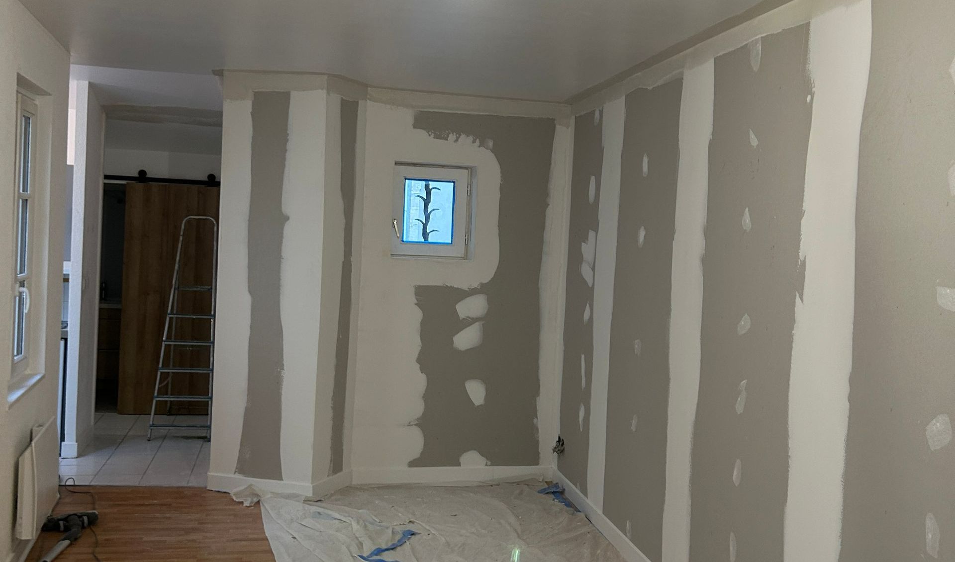Pose de cloisons dans une pièce avec une petite fenêtre