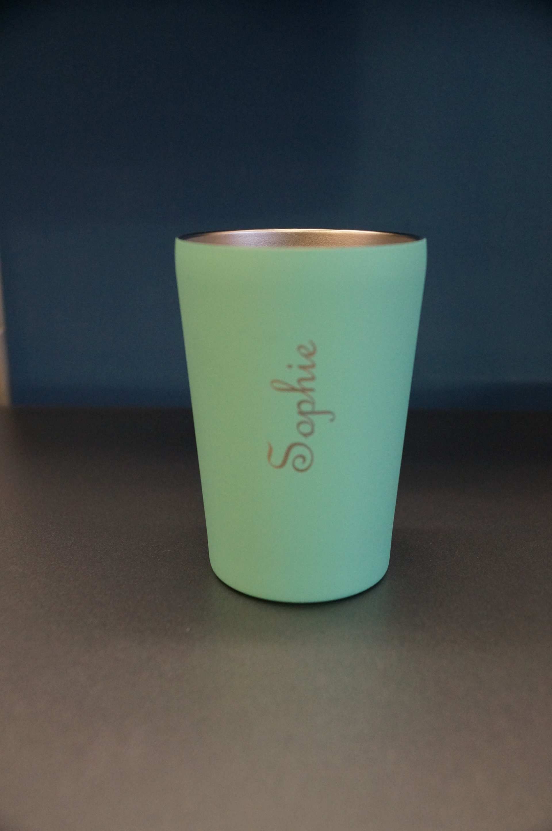 Ein türkiser Becher mit der Gravur